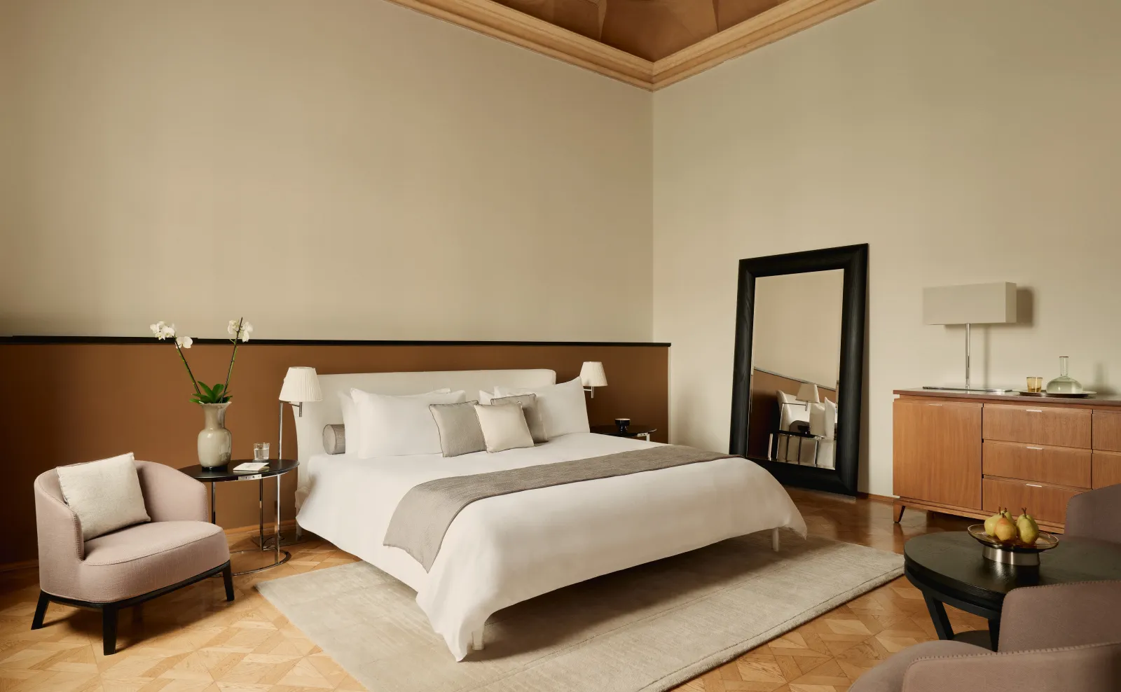 The Papadopoli Stanza Canal Grande: the bed, an armchair and a tall mirror, under the high ceiling.