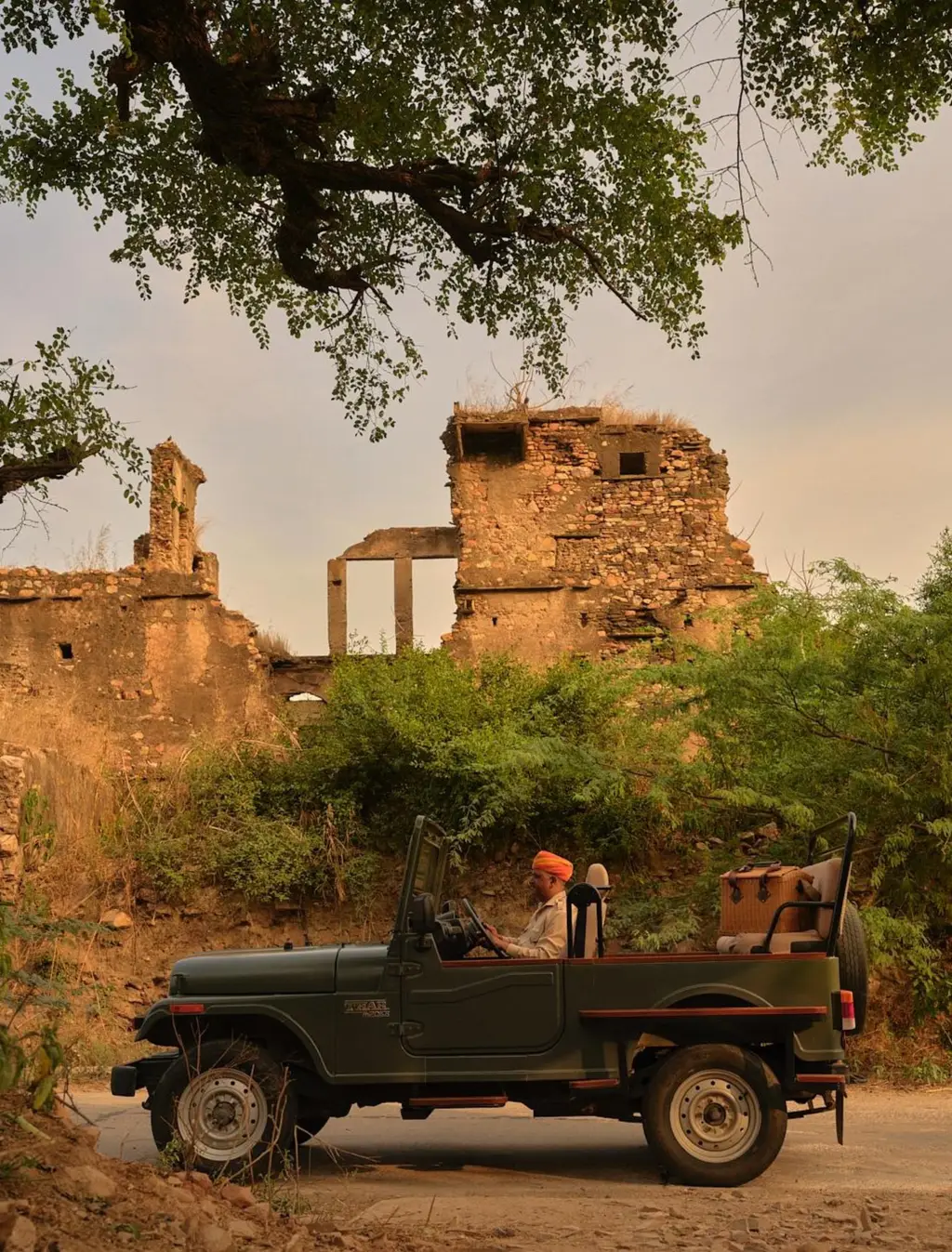 The resort’s jeep on a dirt road beside a ruined building