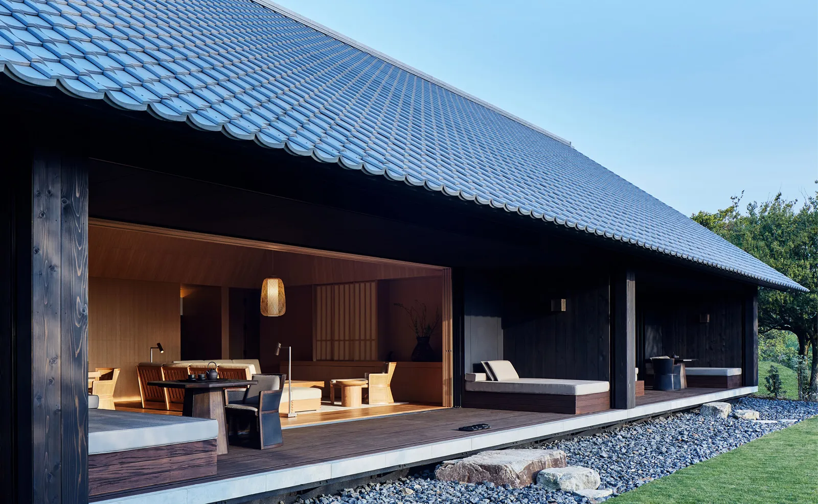 The open-sided living pavilion under a tiled roof, a lawn in front