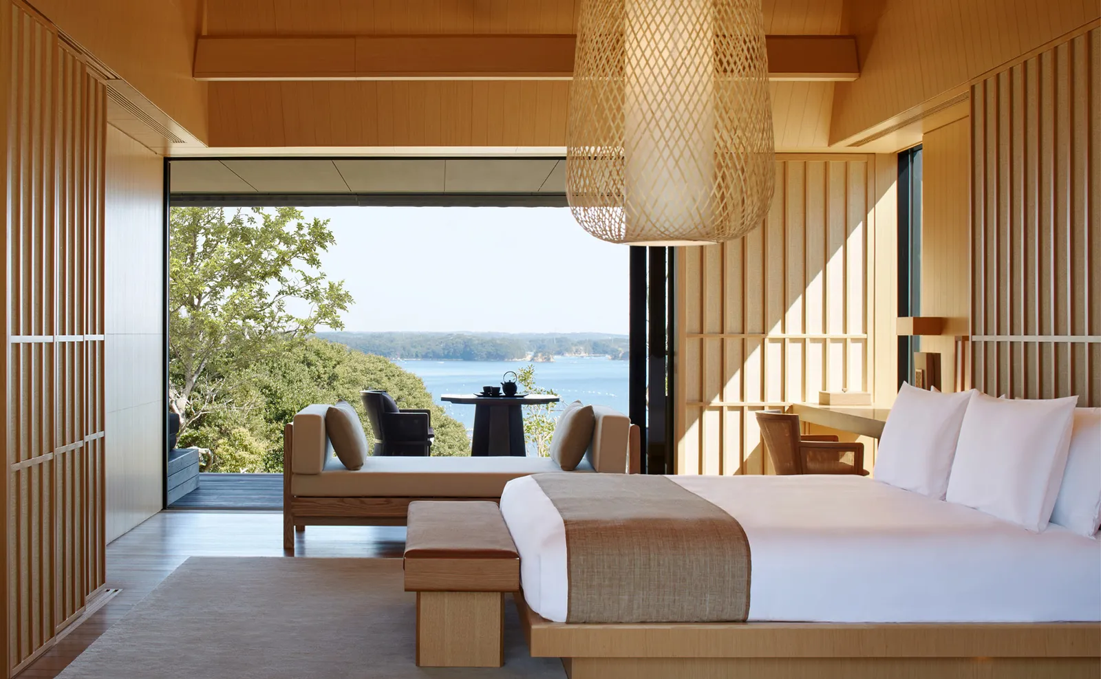 Bed, daybed and veranda, trees and a strip of bay beyond
