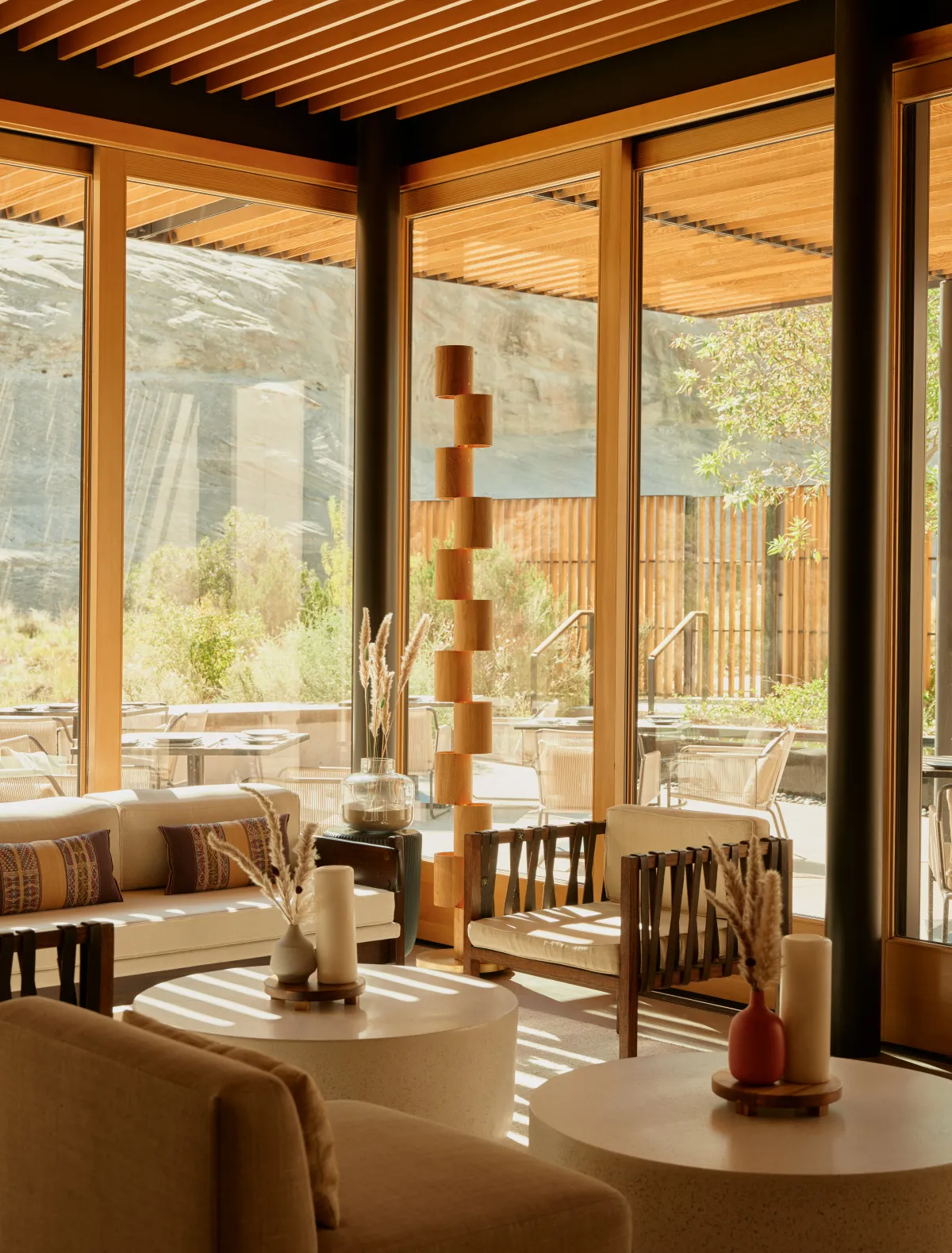 Camp Sarika’s restaurant: pale sofas and round tables between glass walls and a slatted timber roof.