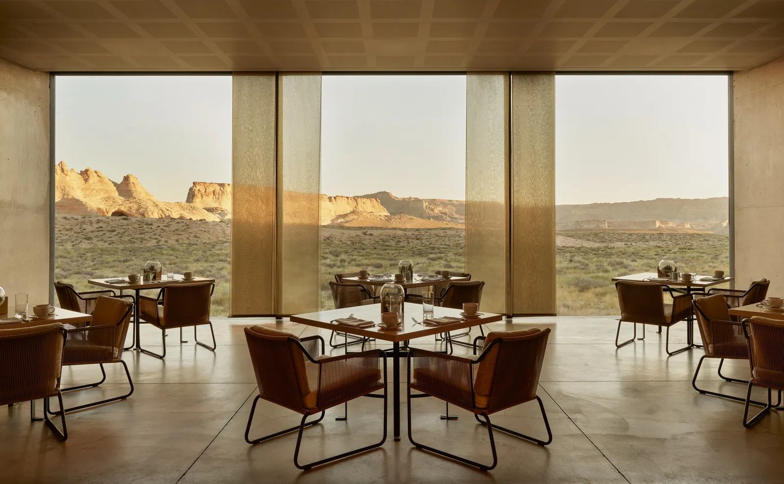 The restaurant: square tables and leather armchairs before floor-to-ceiling windows onto the desert.