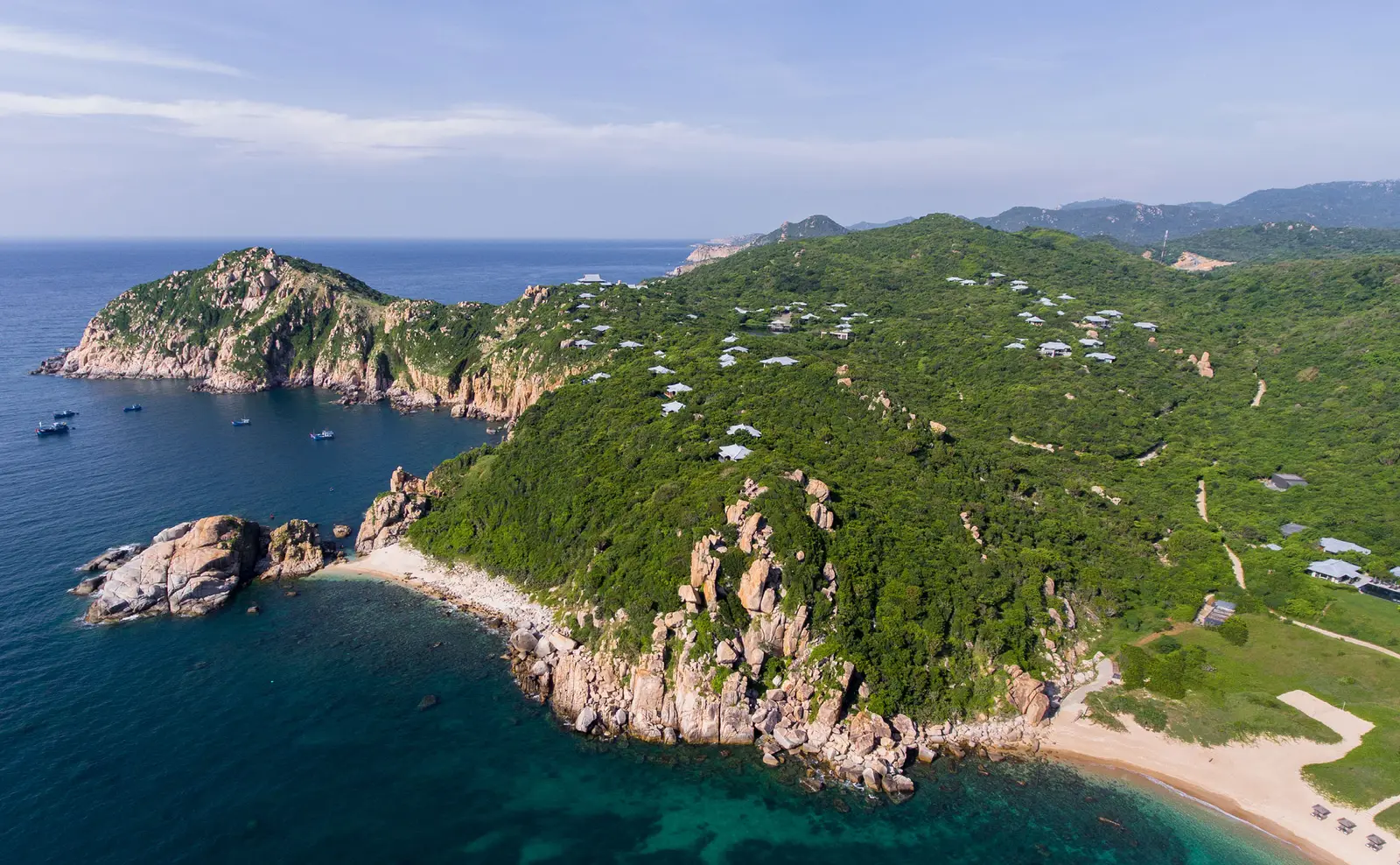Amanoi’s headland from the air: the pavilion roofs among the green, the private beach below and Vinh Hy Bay beyond the rocks