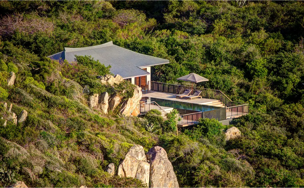 An Amanoi Ocean Pool Villa above the cliff, its deck and long pool among the boulders