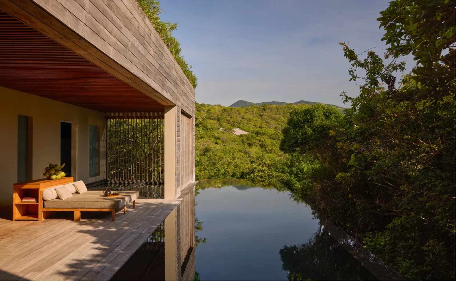The Forest Wellness Pool Villa deck with a timber daybed above the pool, in the forest