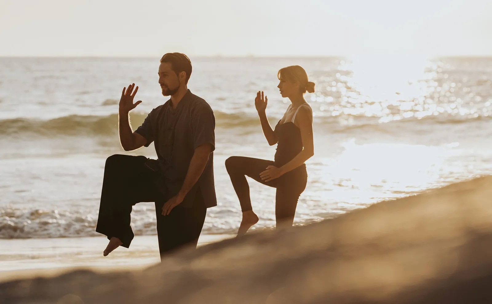 3 people doing yoga on the beach at sunrise