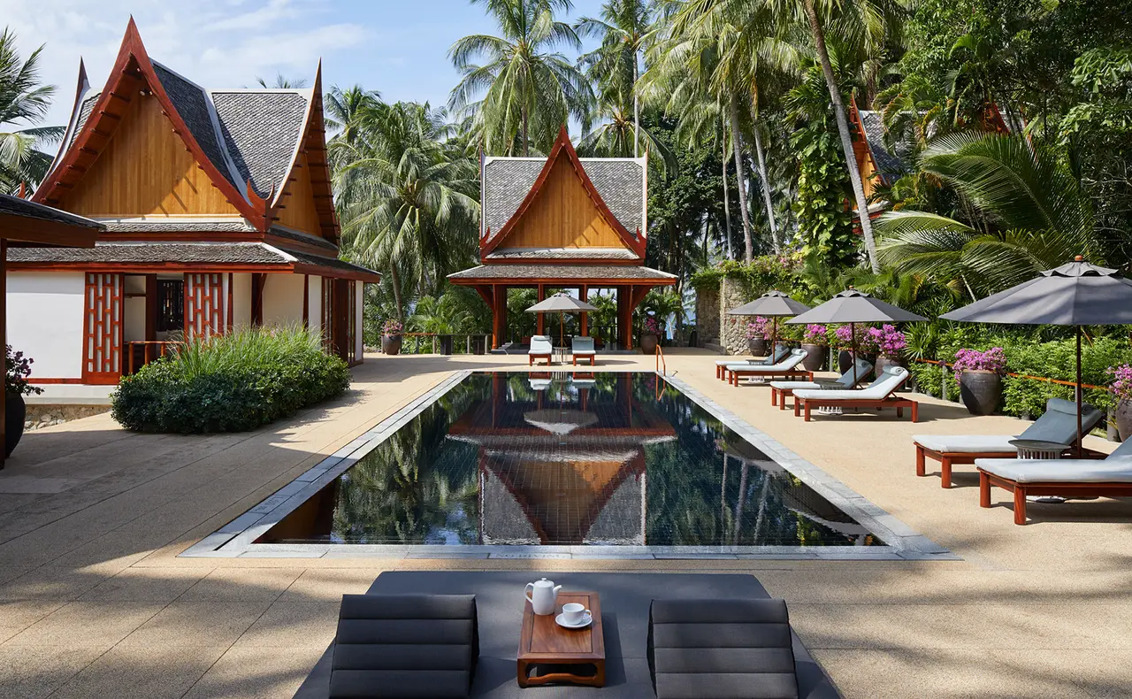 A courtyard pool between red-roofed villa pavilions