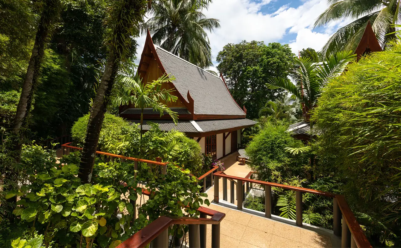 A Garden Pavilion seen from its walkway, the teak roof among the trees