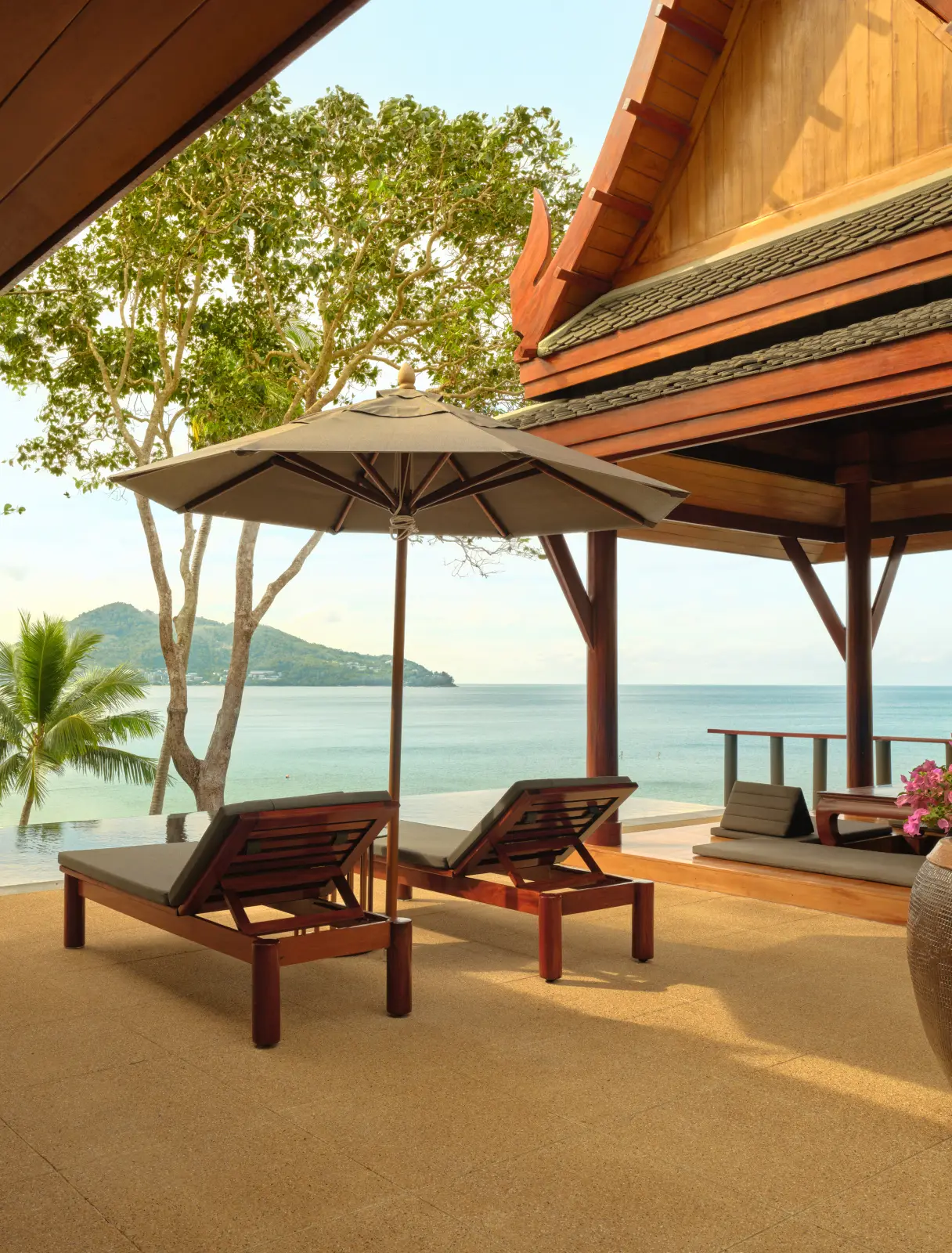 Loungers under a parasol on a terrace above the sea