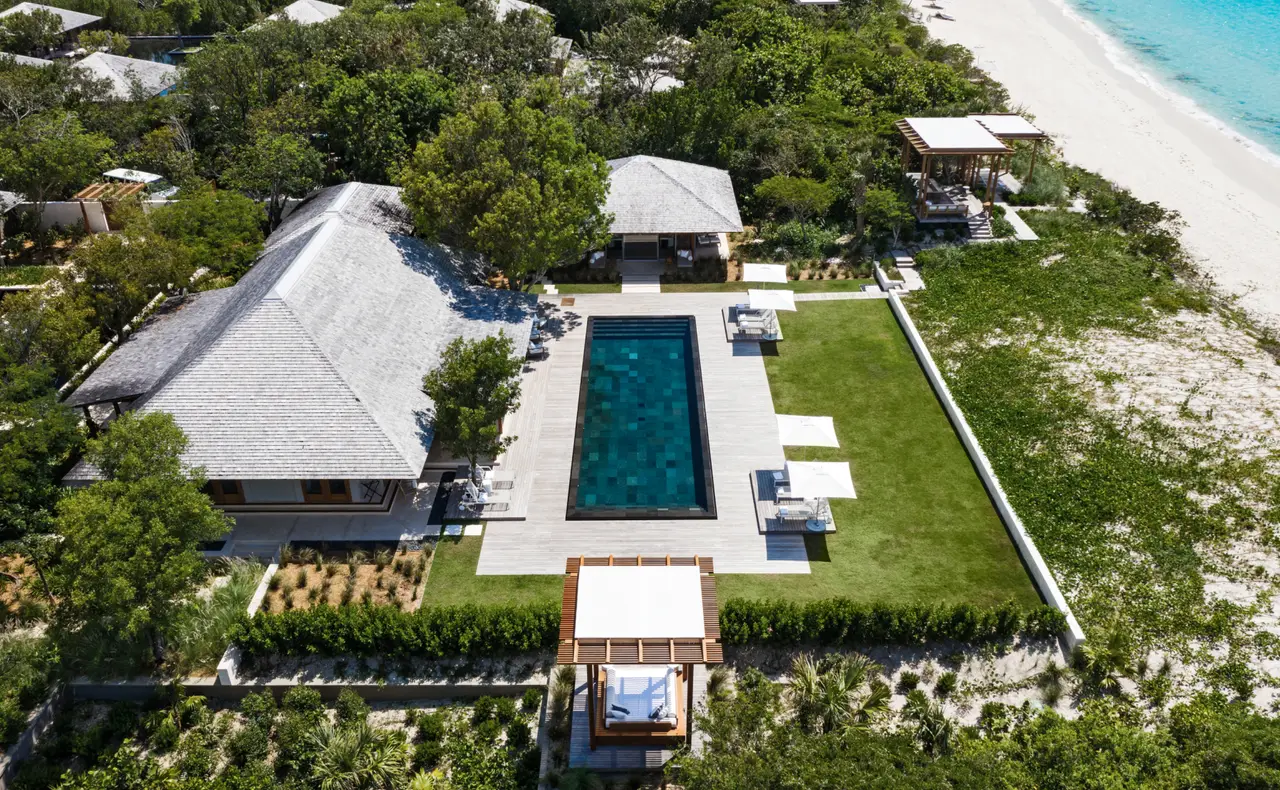 A Beach Sala Villa from above: the long pool in its lawn, the pavilion roofs and the beach at top right.