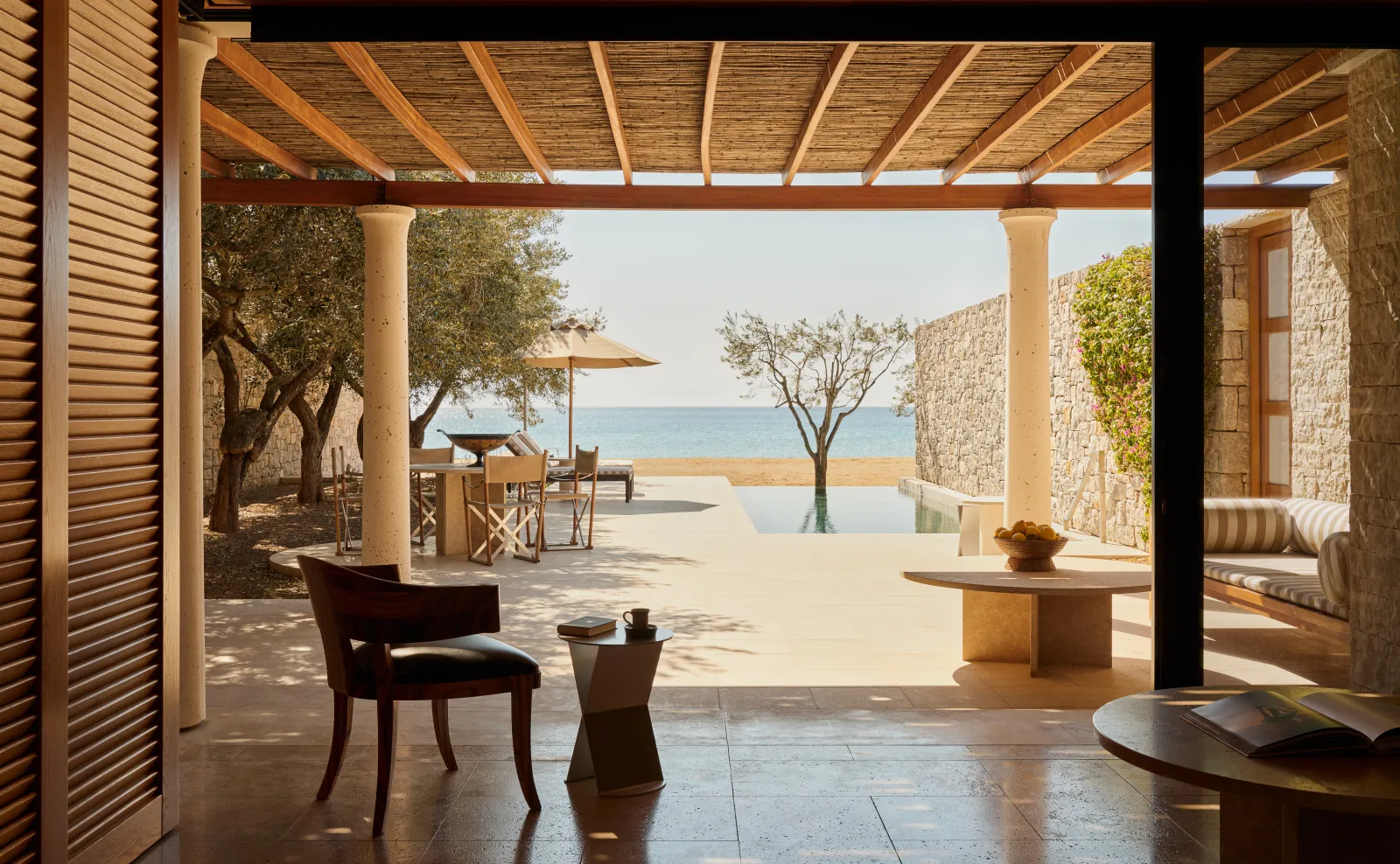 A Beach Pavilion’s terrace seen from inside: the pergola, the pool and the beach a few steps away.