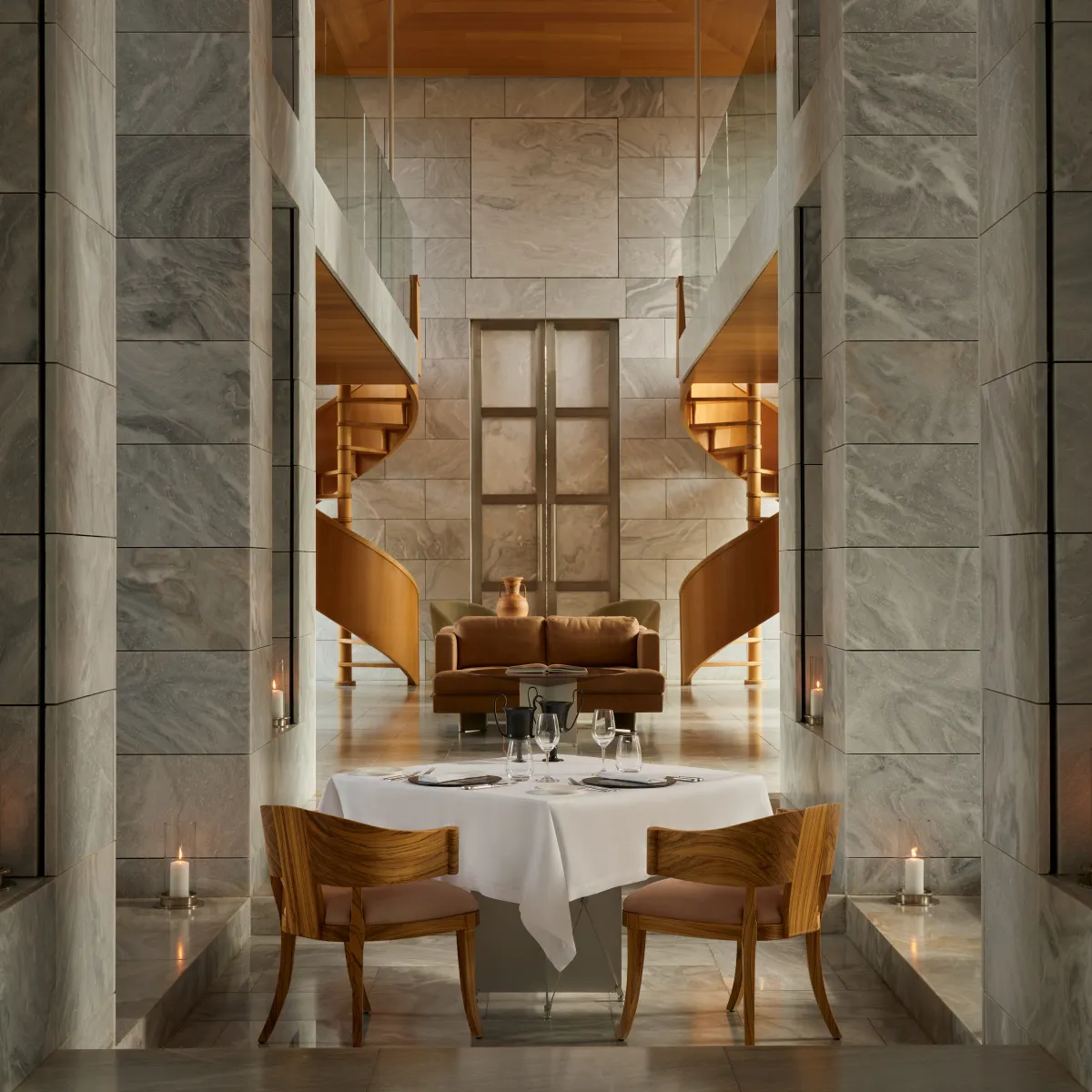 A candlelit dinner in the Library: a table for 2 between marble columns, before the wooden spiral staircase.