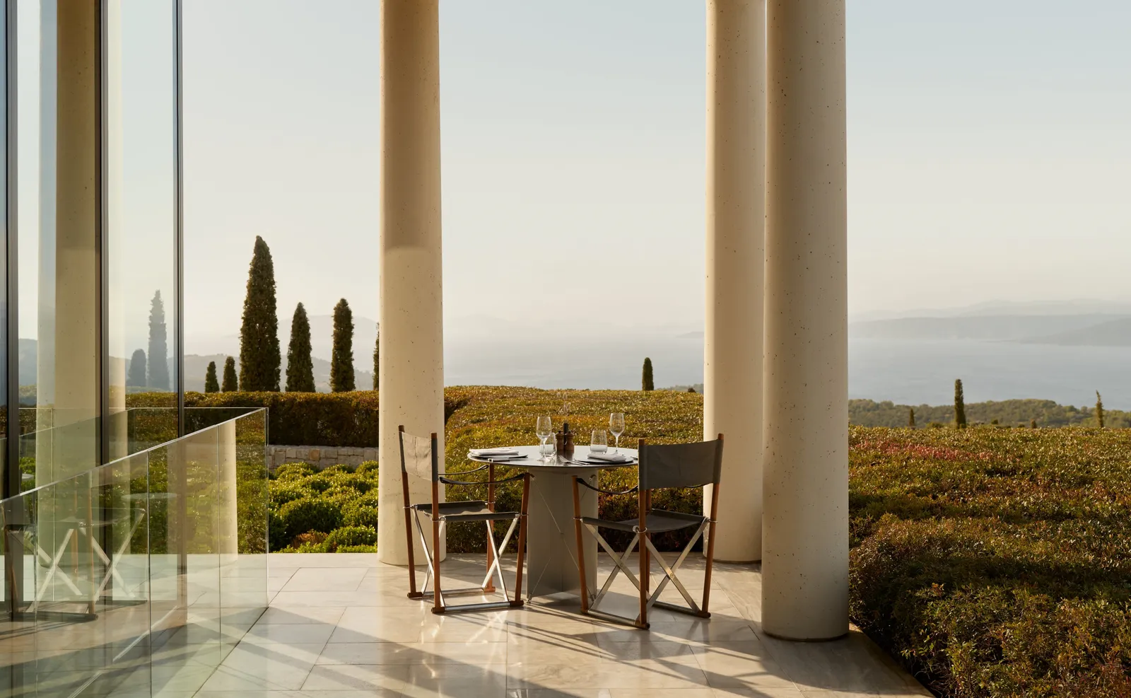 A table for 2 on the restaurant terrace, between columns, above the lavender gardens and the sea.