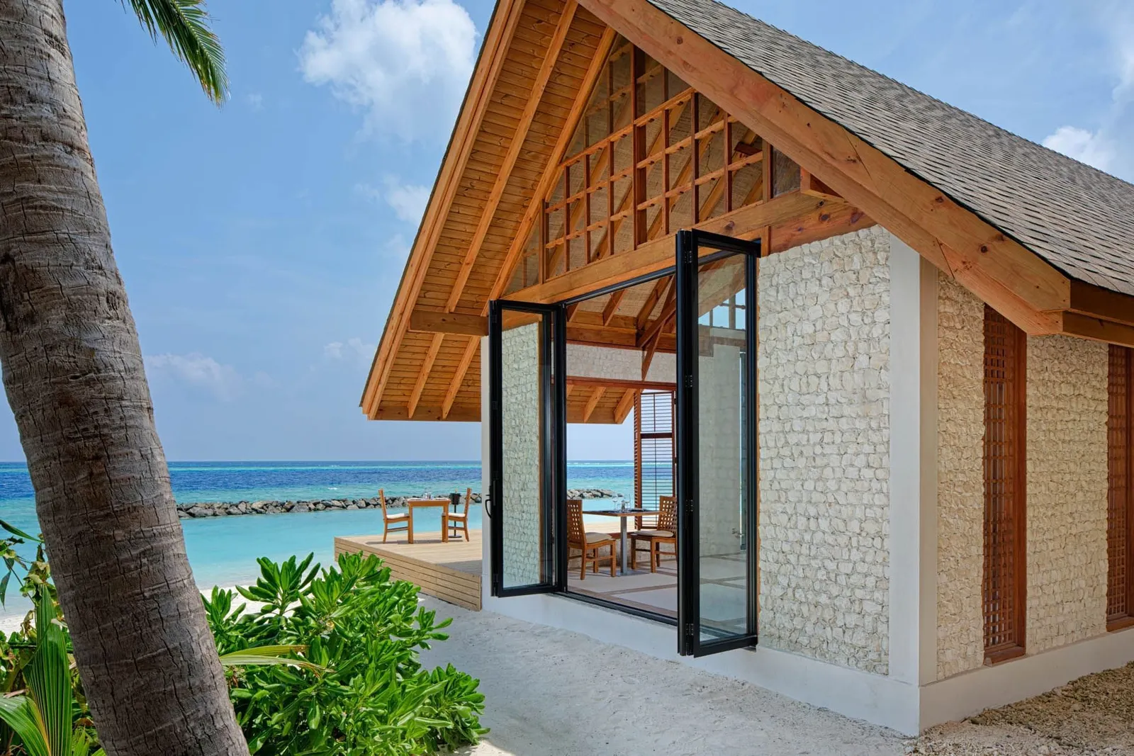 One of the Asian Food Street pavilions, its terrace on the sea and a rock breakwater along the shore.