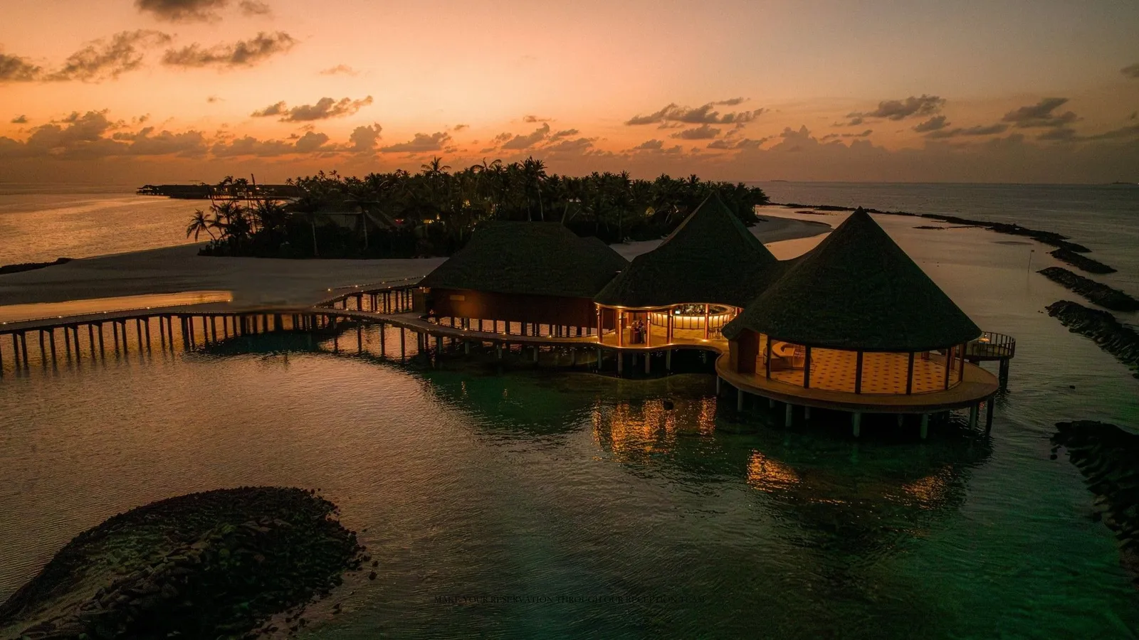 Luna, the restaurant over the water between the 2 islands, lit up at dusk.