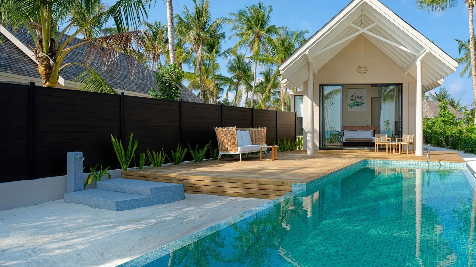 A Beach Pool Villa’s private pool in front of the house, among the palms.