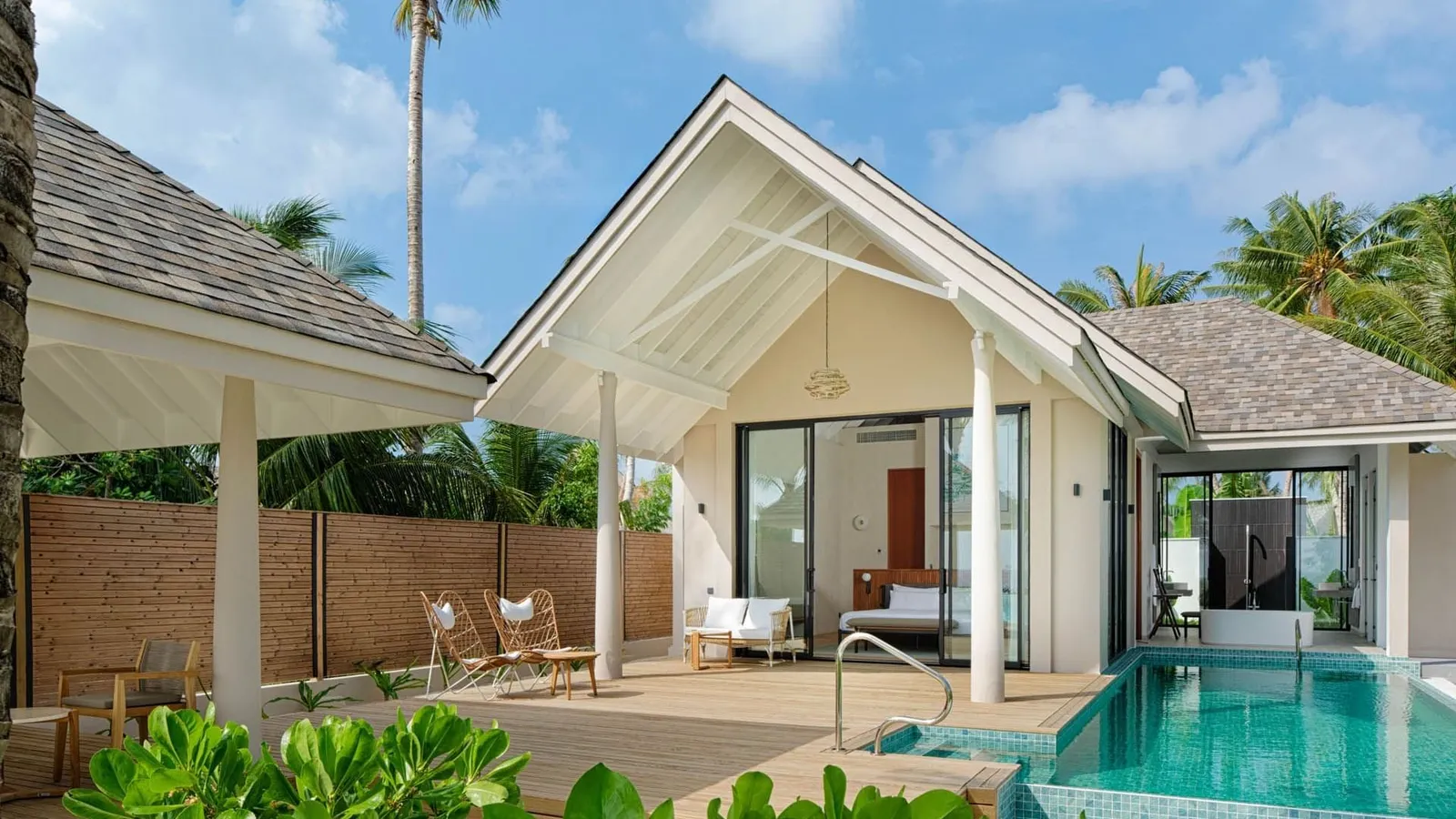 A Deluxe Beach Pool Villa among the palms, its pool beside the deck.