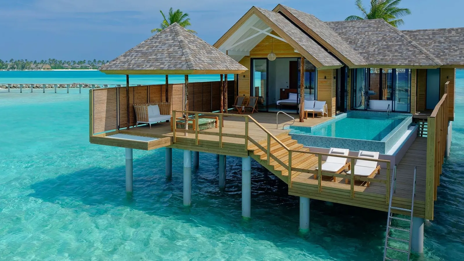 A Deluxe Water Pool Villa over the lagoon, with its pool, pavilion and ladder into the sea.