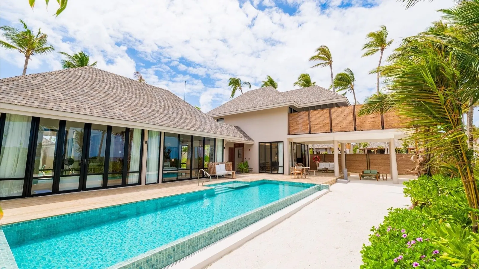 The long pool of a Kimbi or Kaani residence, in front of the house’s glass walls.