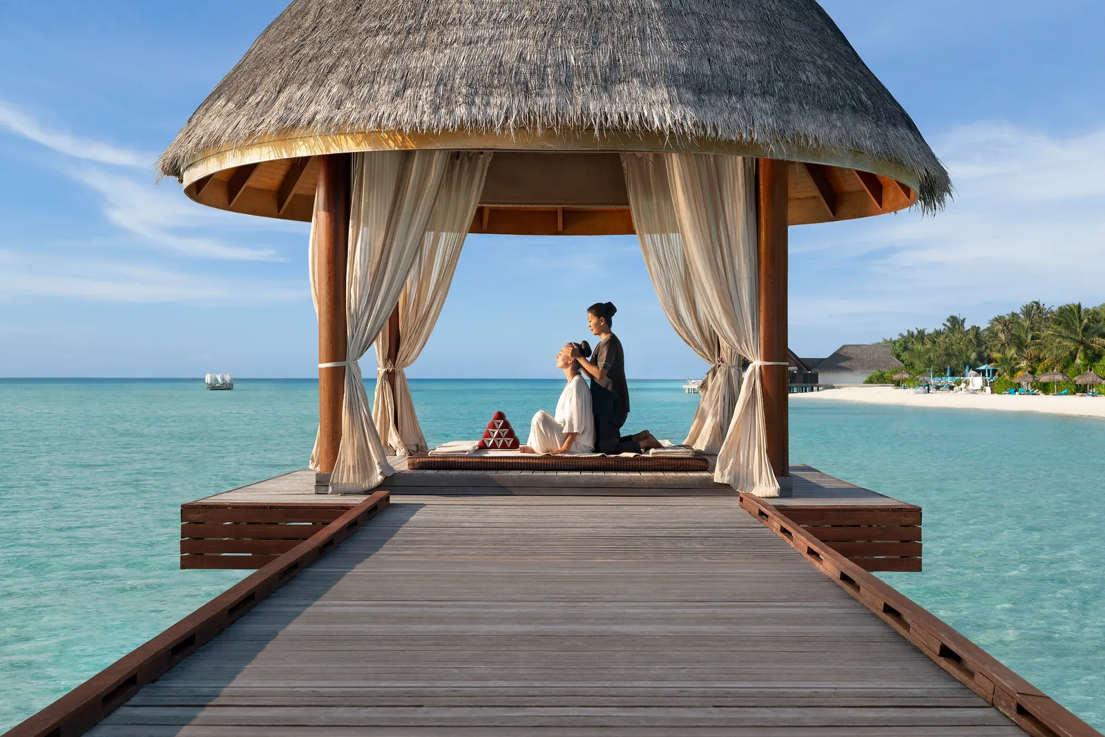 Un massaggio thai in una sala aperta in fondo al pontile della spa, fra le tende bianche e la laguna.