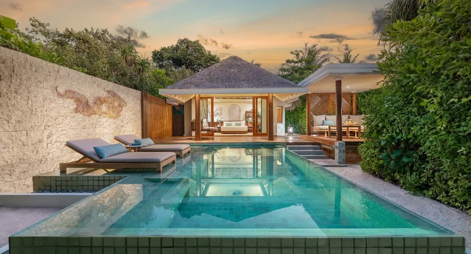A Sunset Beach Pool Villa at dusk, its pool lit