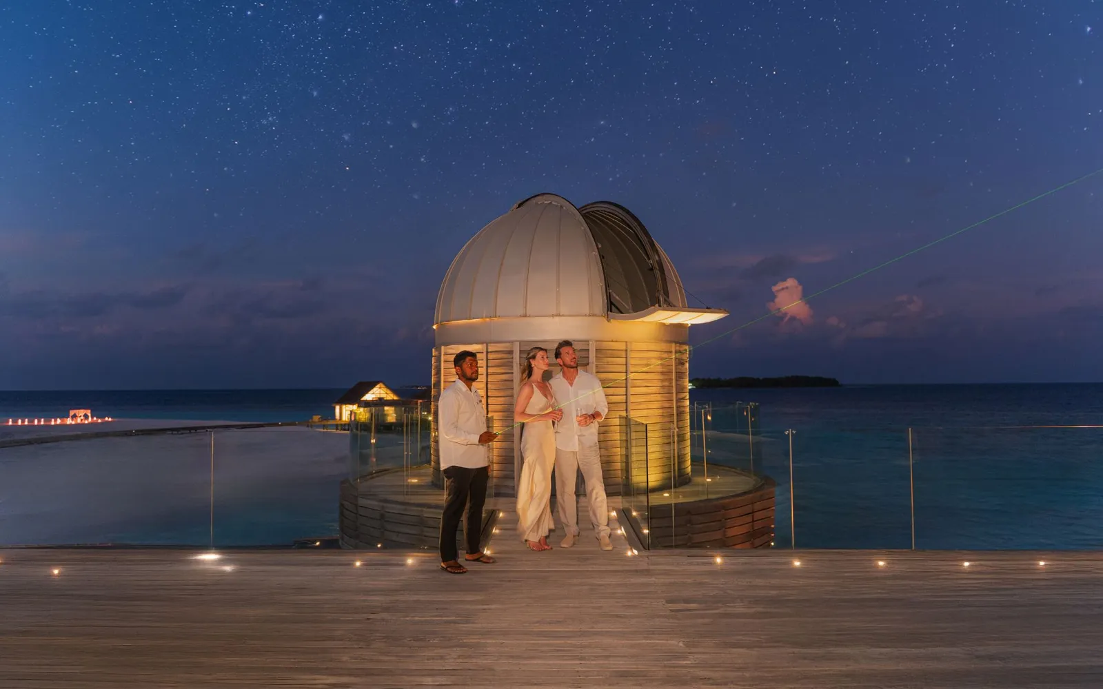 A couple on SKY’s terrace at sunset, the observatory dome behind them