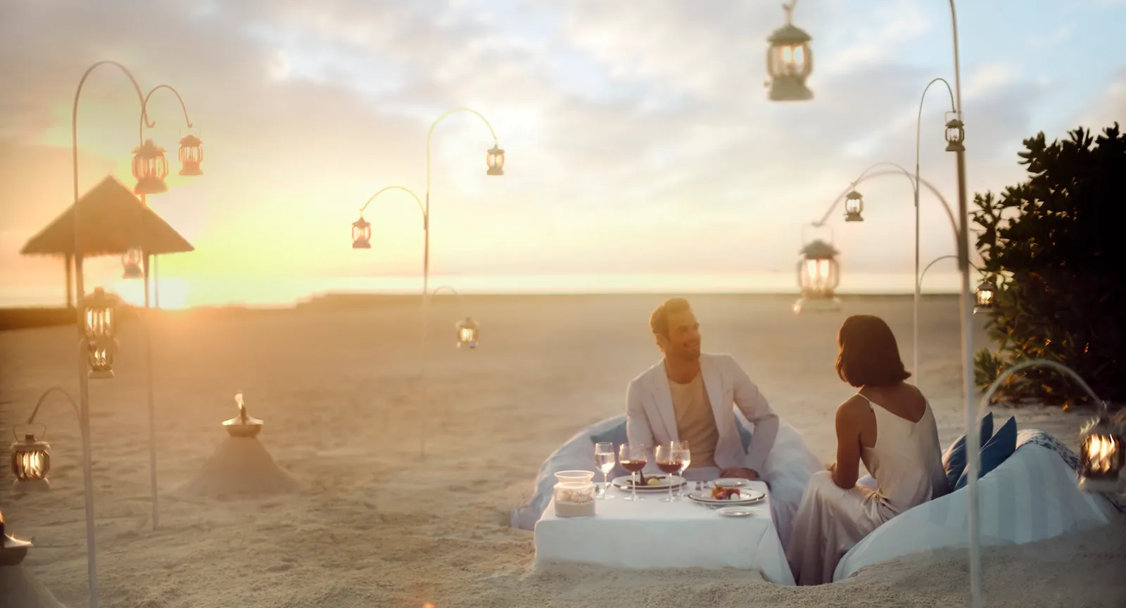 Una tavola per 2 sulla spiaggia al tramonto, tra le candele