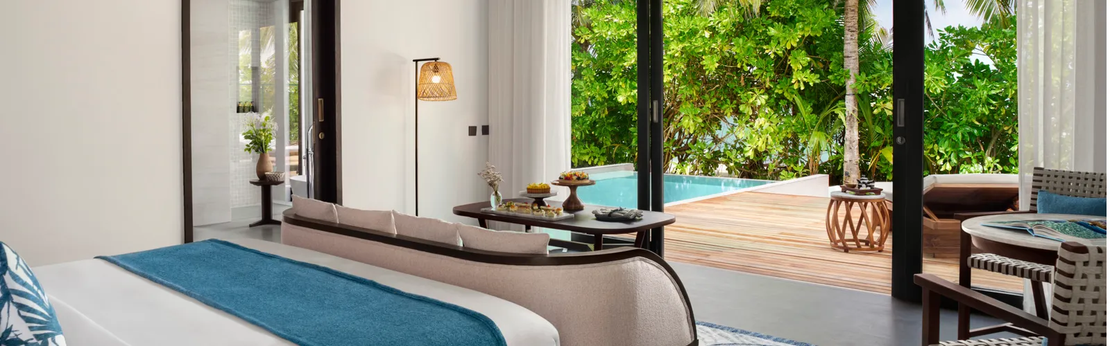 La camera della Beach Pool Villa, il letto e le vetrate verso l’esterno
