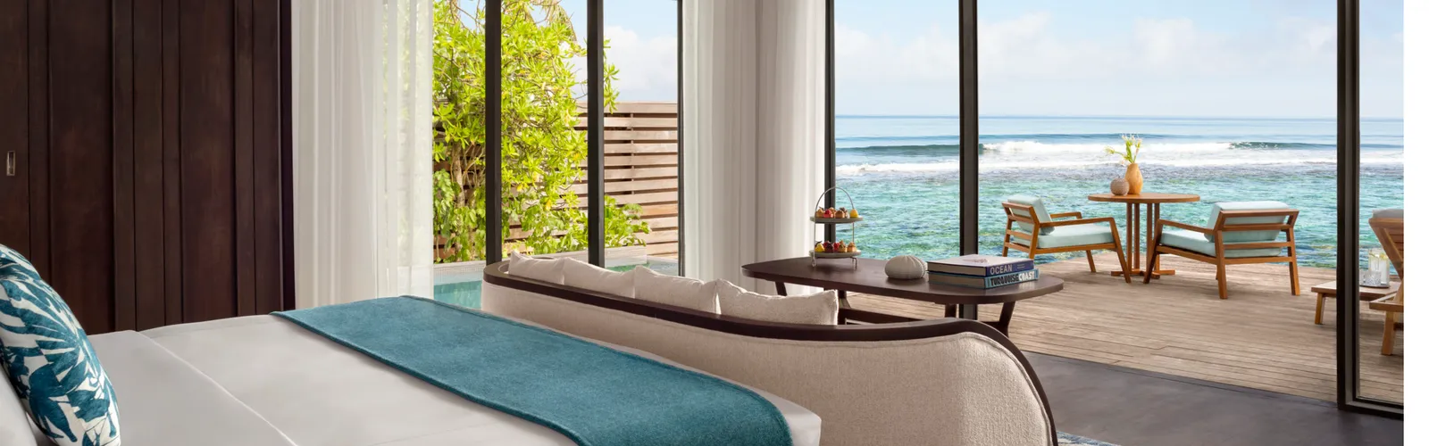 La camera della Ocean Pool Villa, il letto e le vetrate verso l’esterno