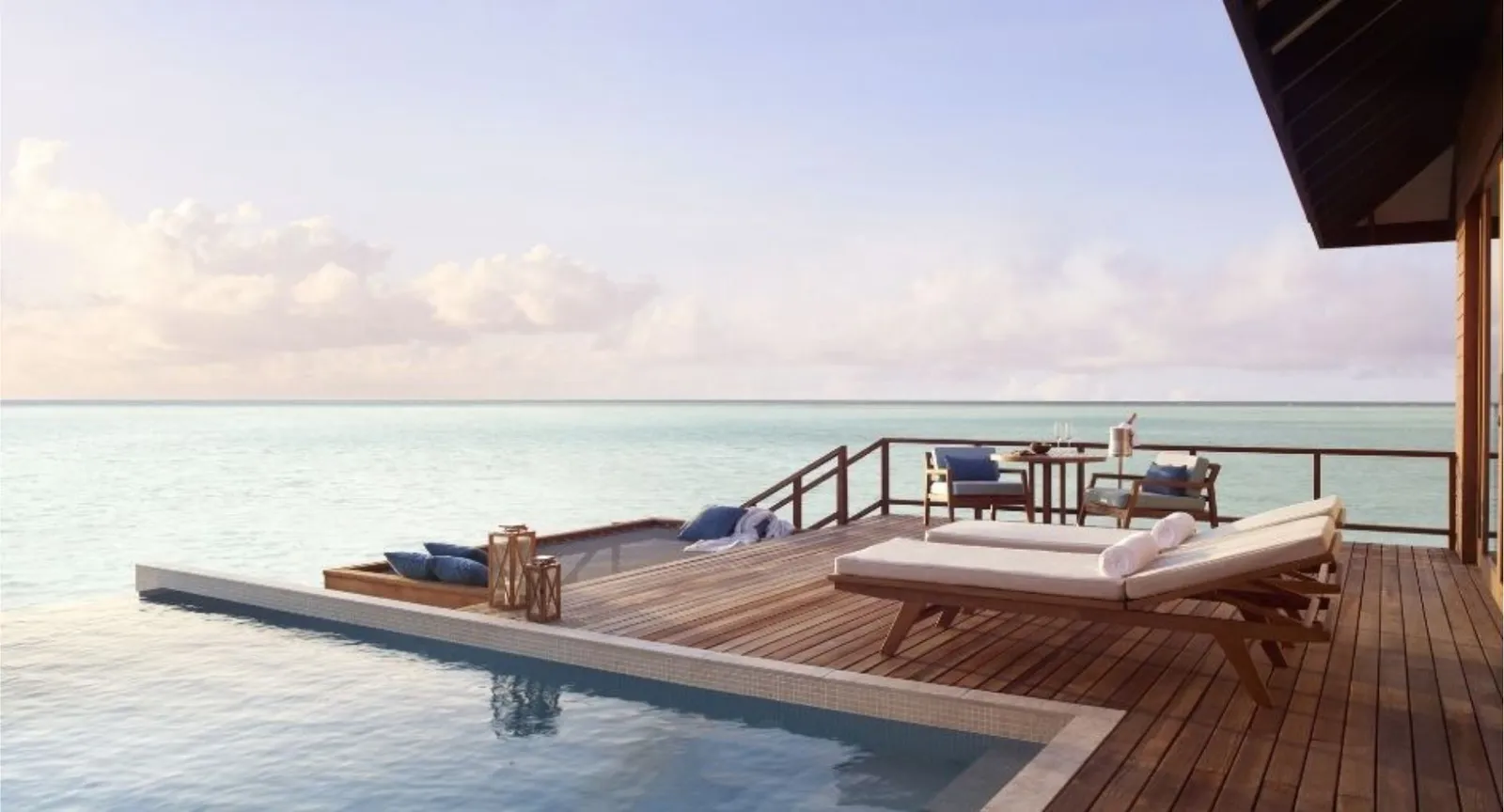 La terrazza di una Deluxe Over Water Pool Villa, con la piscina e i lettini affacciati sul mare