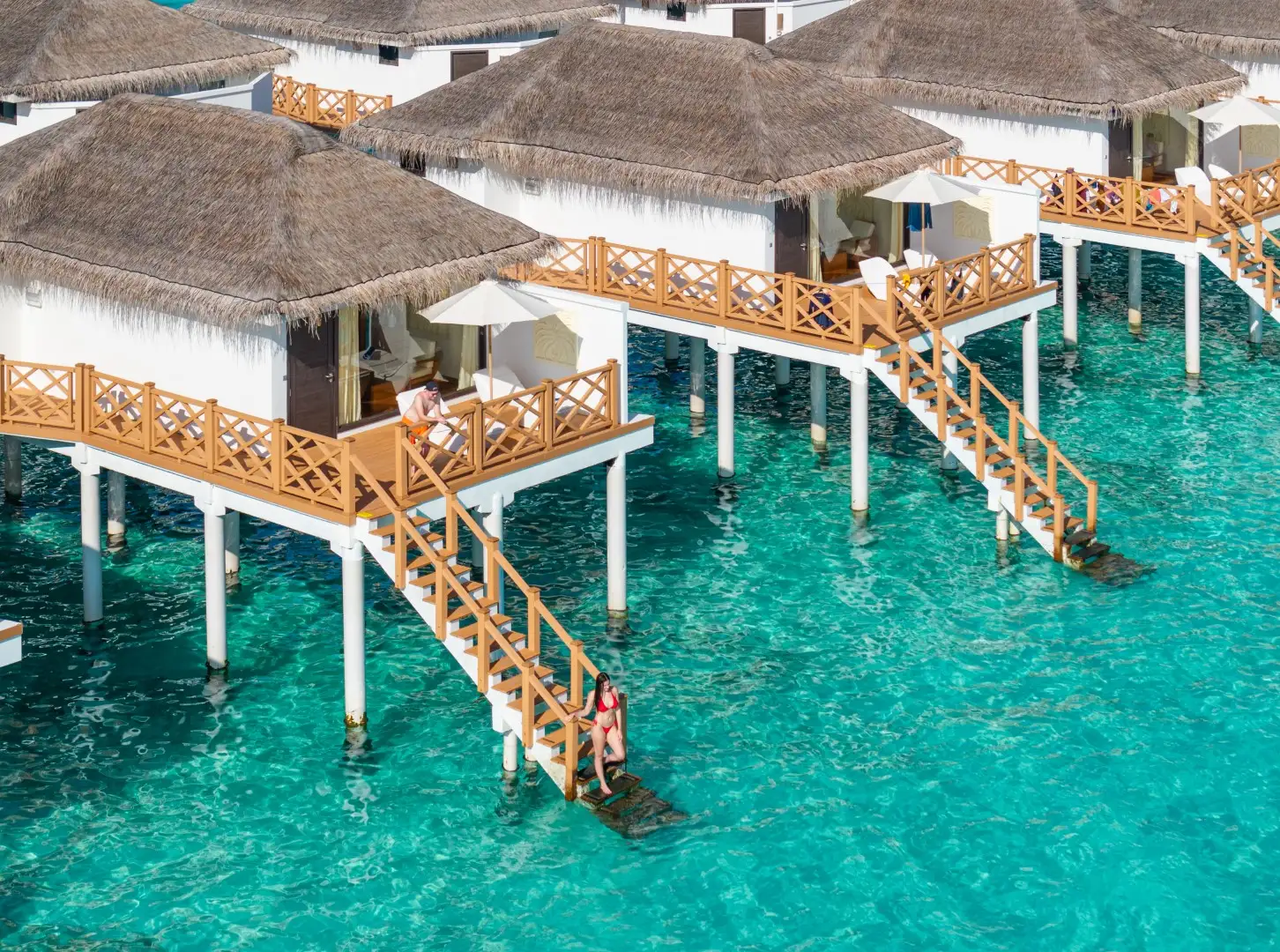 I Premium Water Bungalow sulla laguna, ognuno con la sua terrazza e la scaletta che scende in acqua.