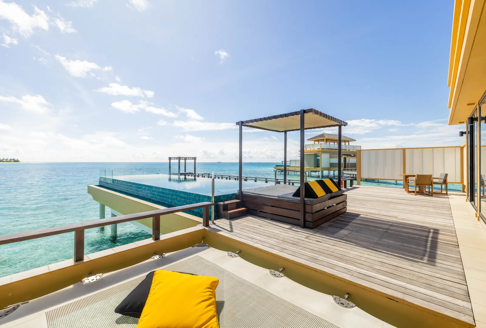The rooftop terrace of a Deluxe InOcean villa, with its canopy daybed, cushions and the ocean all round.