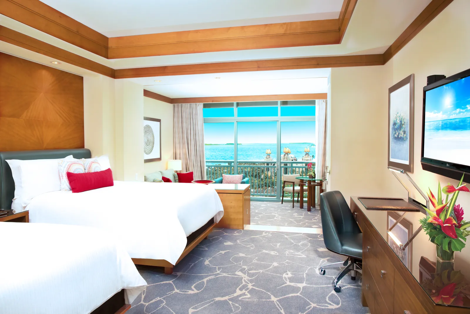 An Ocean Suite at The Cove with 2 queen beds, a step-down sitting area and a balcony over the sea.