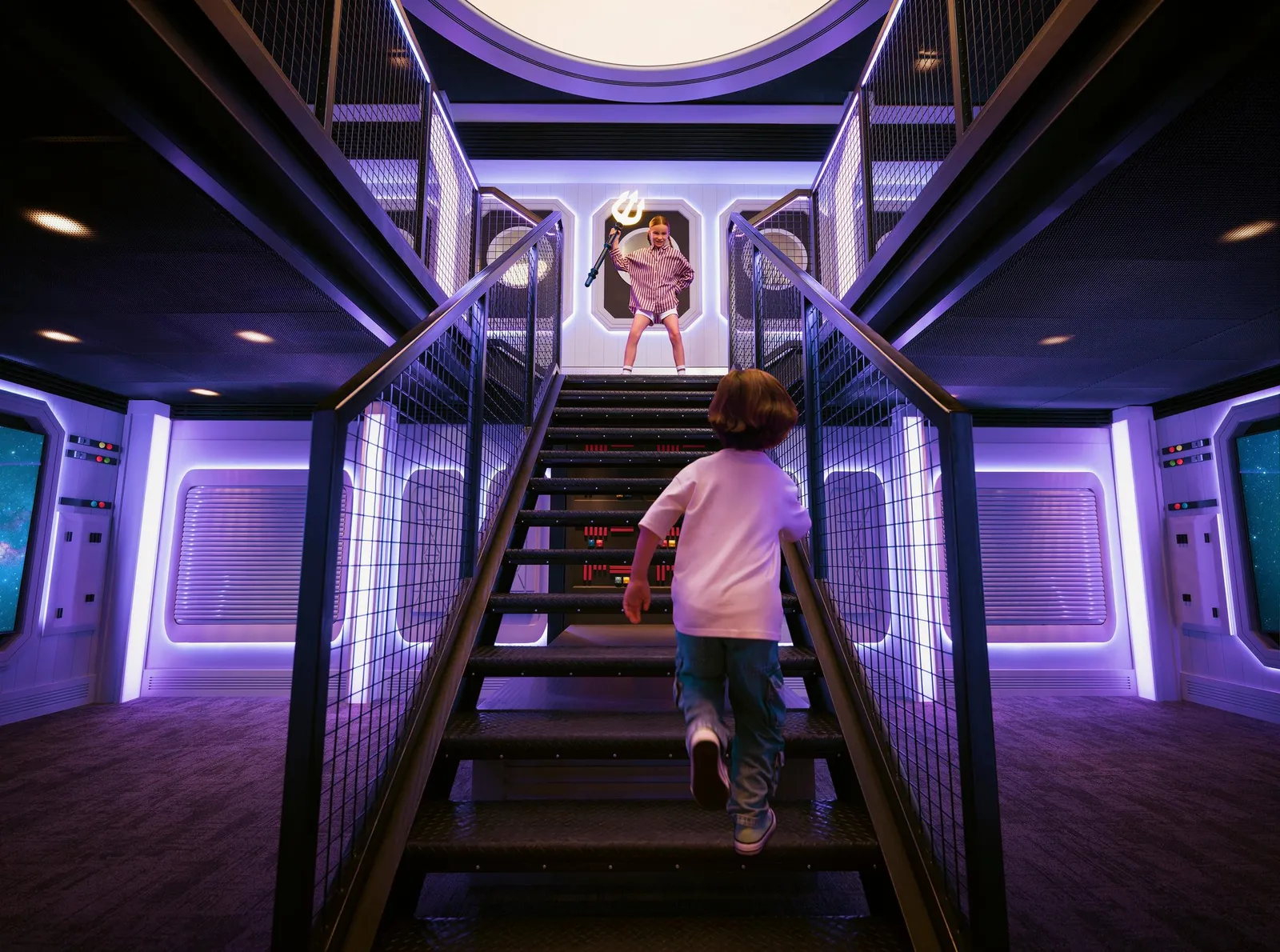 A child climbing the lit stairs of the Atlantis Explorers Club