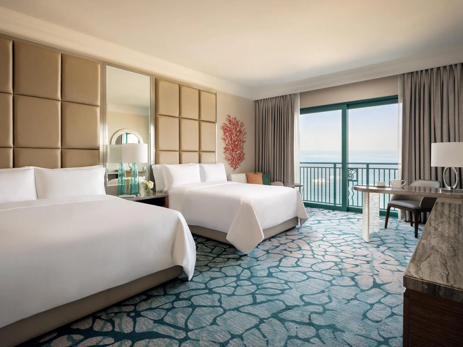 A room with a king bed and a second bed, facing the sea