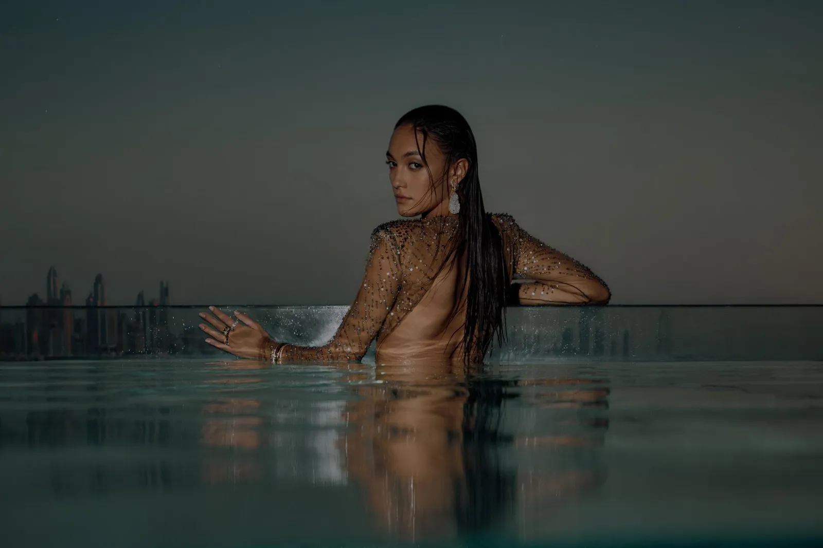 A guest in the infinity pool at dusk