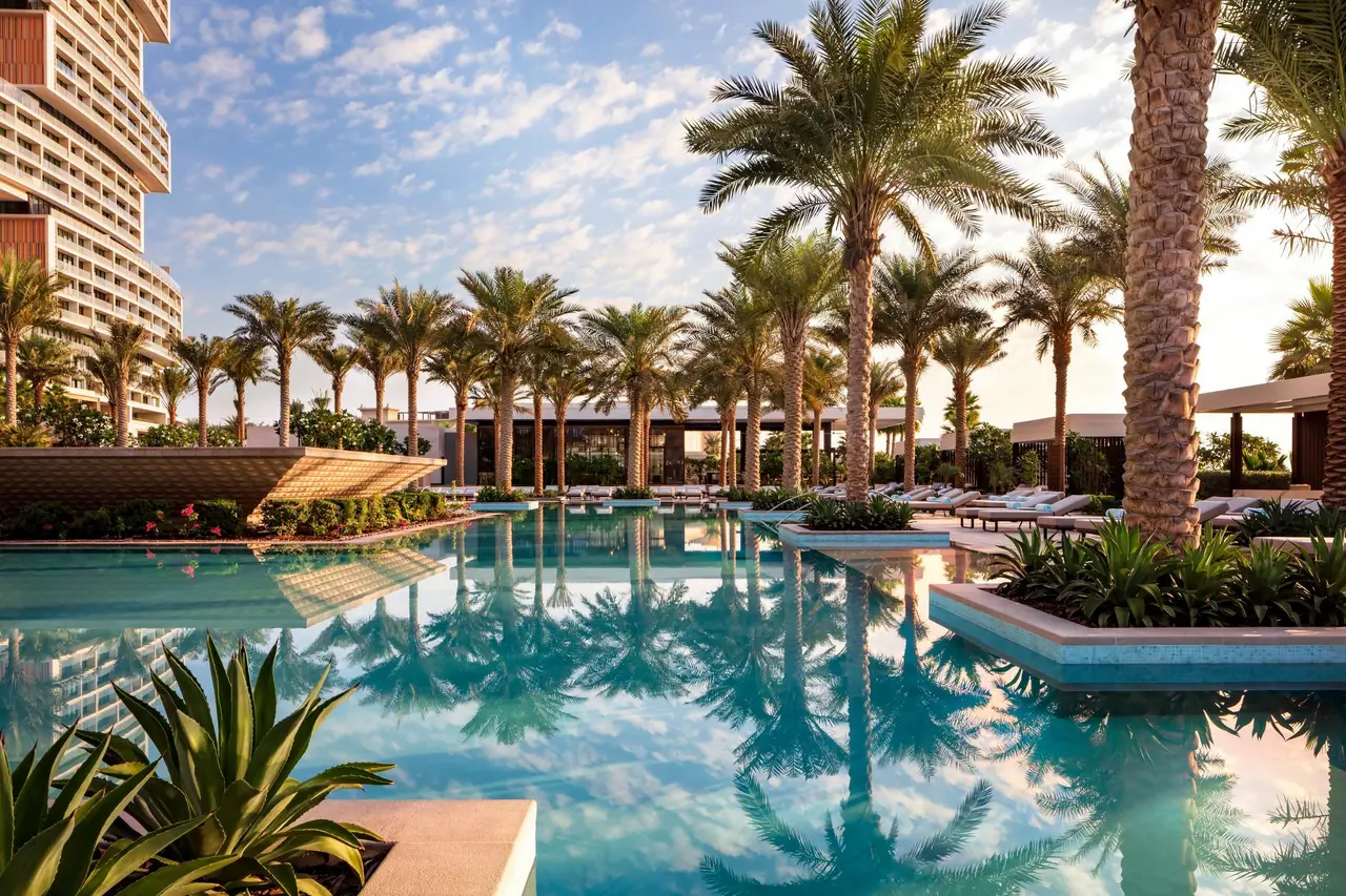 The Nobu by the Beach pool among palms, the tower behind