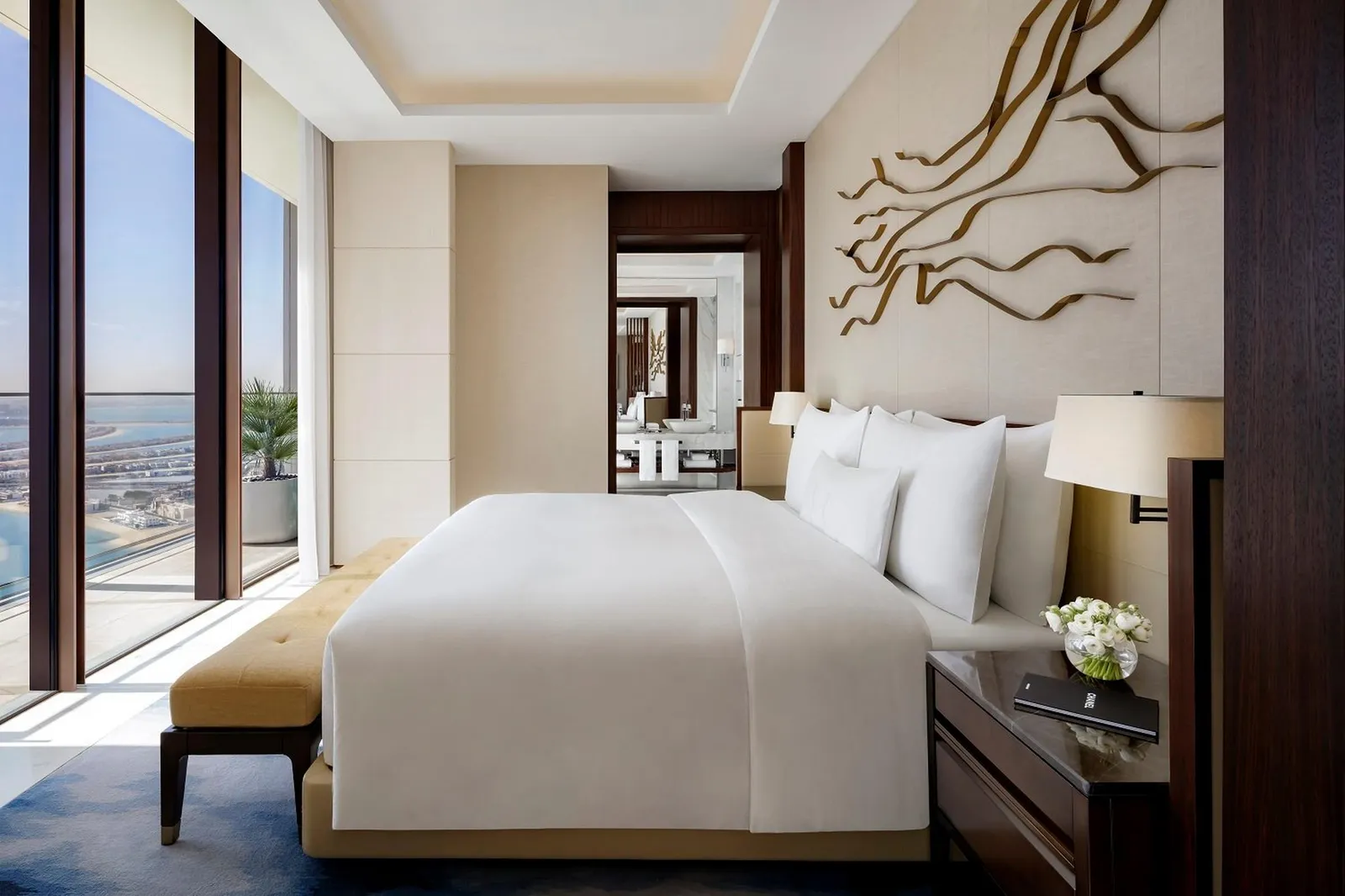 The Junior Sky View Suite bedroom with glass walls onto the city