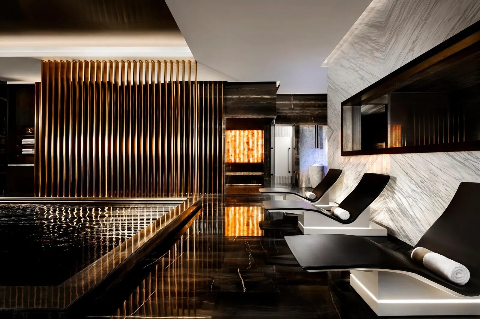 The AWAKEN spa’s thermal area with black loungers and a salt wall
