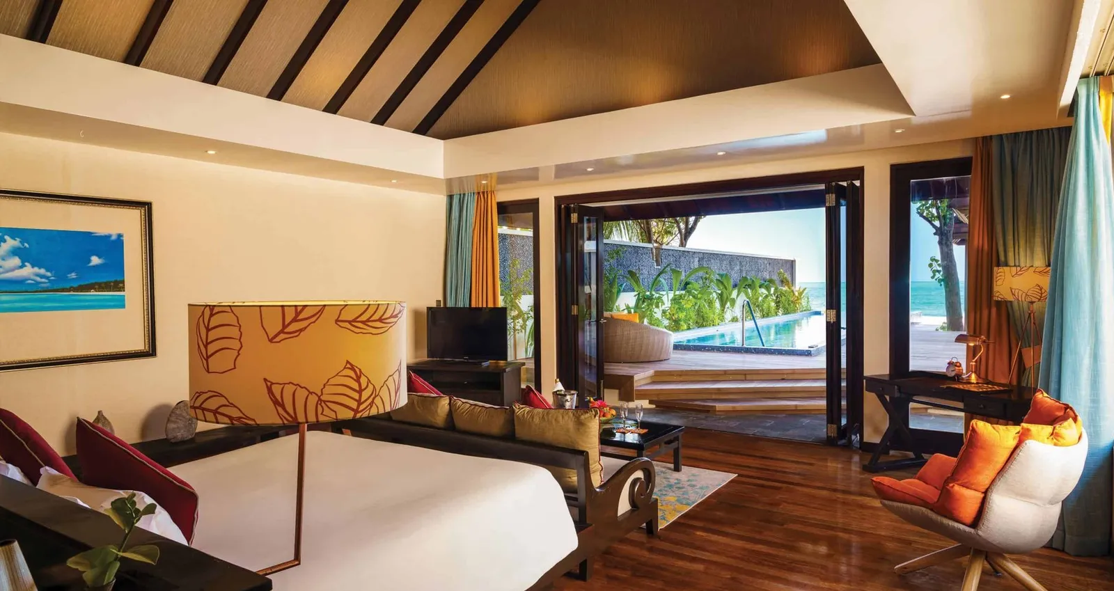 A Kanifushi Grand Pool Villa bedroom, open to the deck and the pool