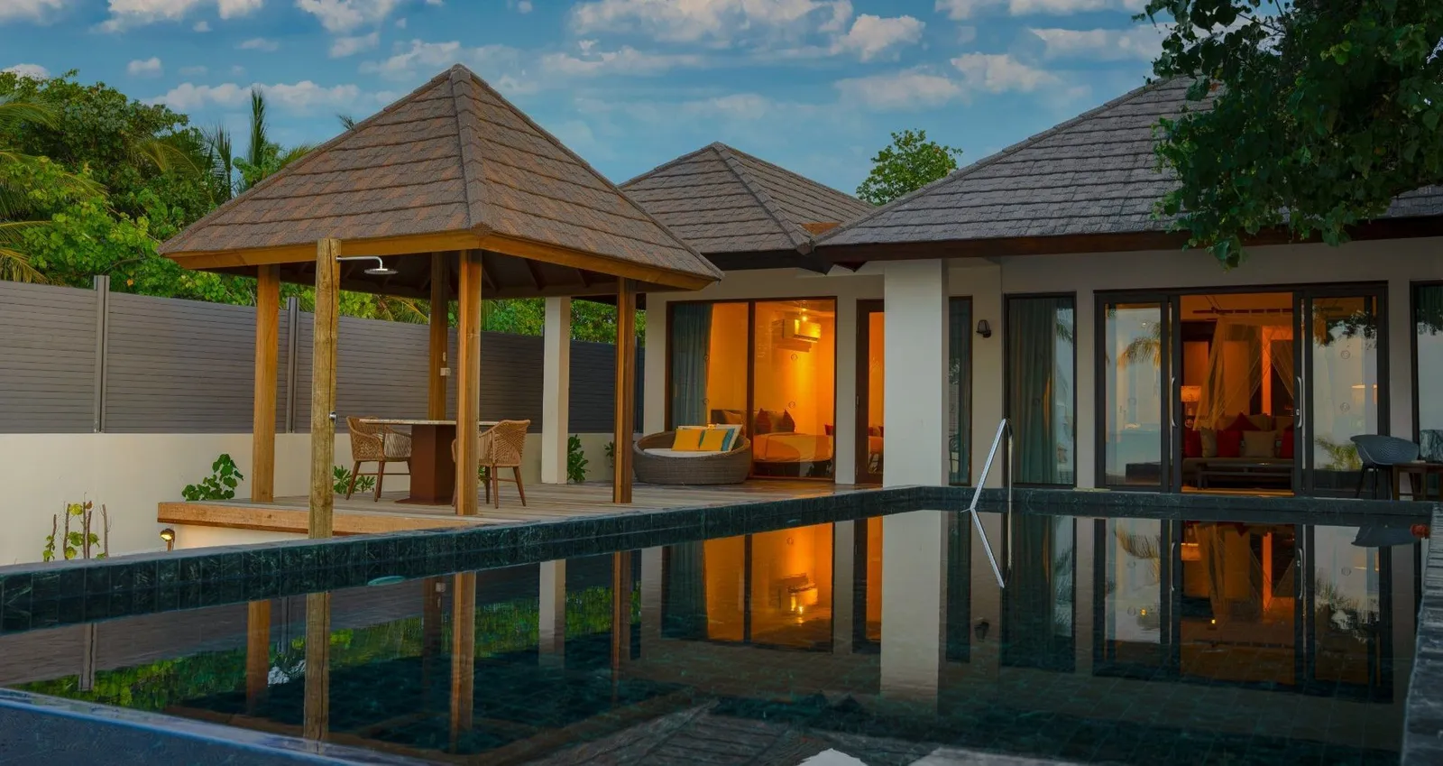 The Two Bedroom Sunset Family Beach Villa with Pool at dusk, the pool before its 2 pavilions