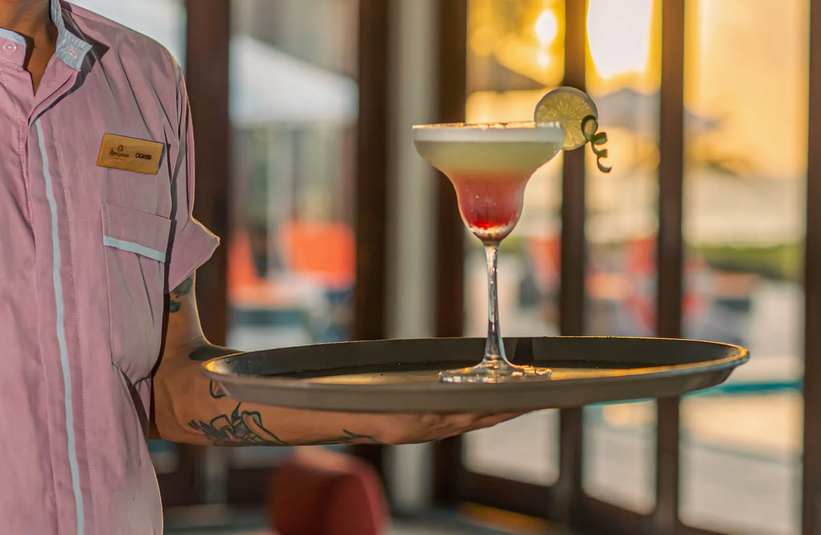 A waiter brings a cocktail on a tray