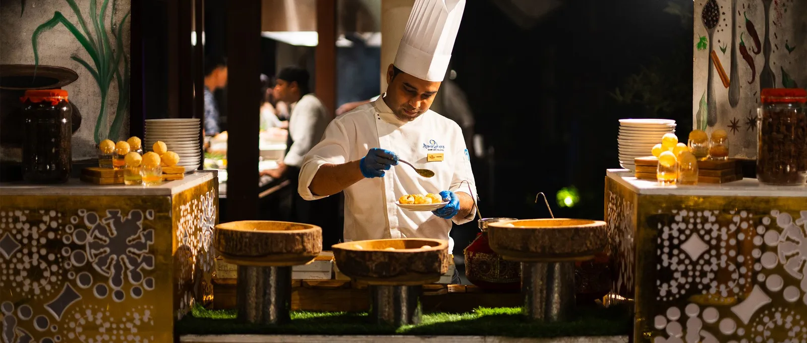 At The Spice a chef plates a dish at the live cooking station