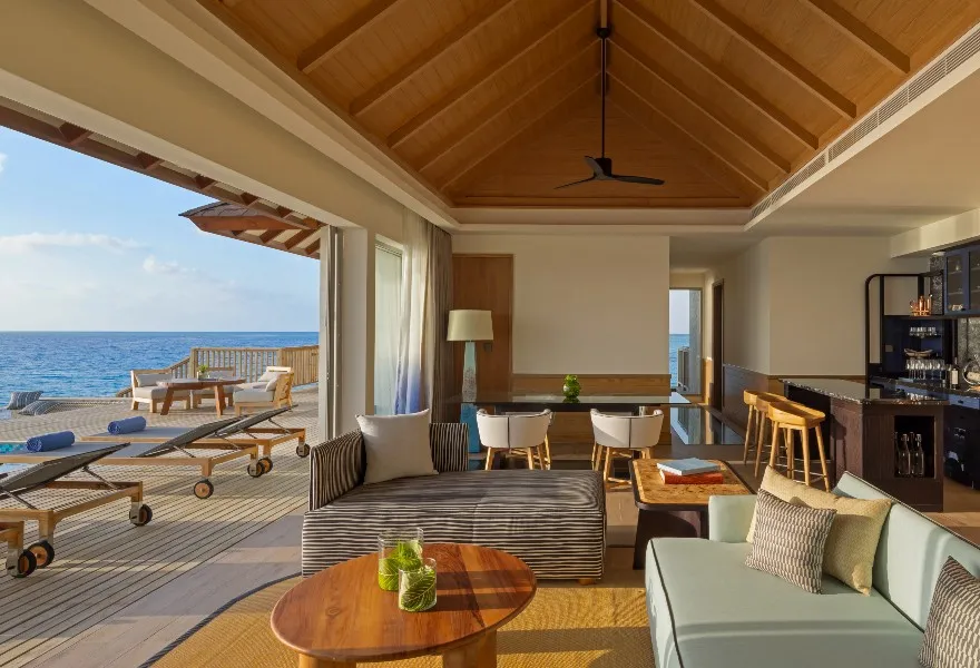 The living room of the 3-bedroom residence: sofas, dining table and the deck over the ocean.