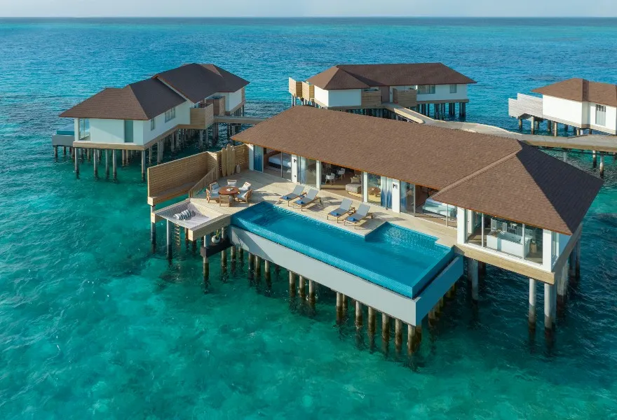 From above, the 2-bedroom residence over the water, its long infinity pool and deck above the lagoon.