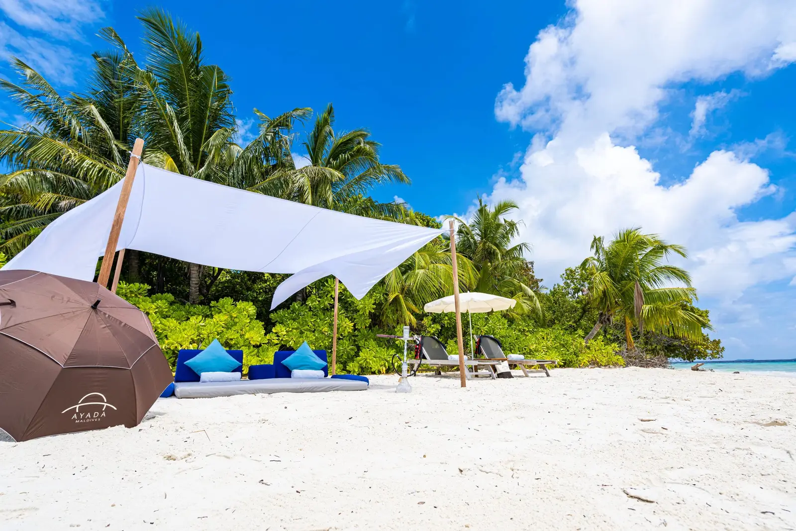 The deserted-island picnic: a white awning and cushions on the sand