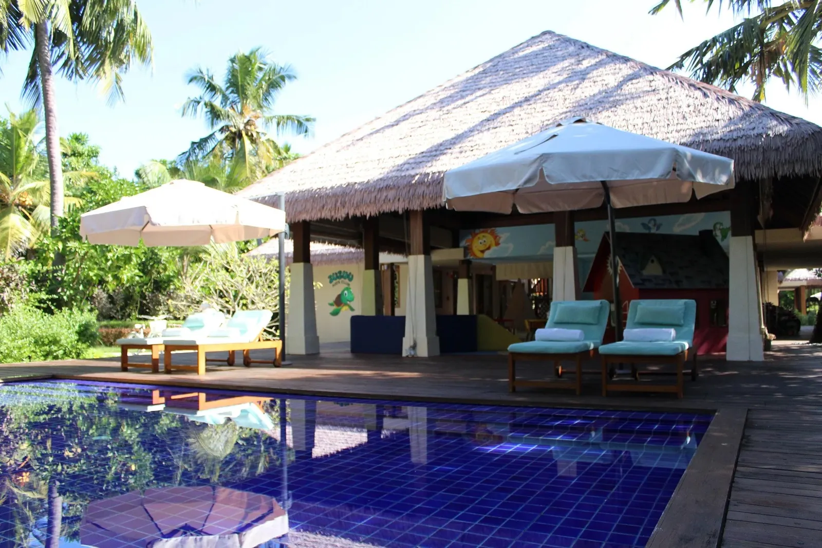 The Zuzuu Kids Club pool before its thatched pavilion