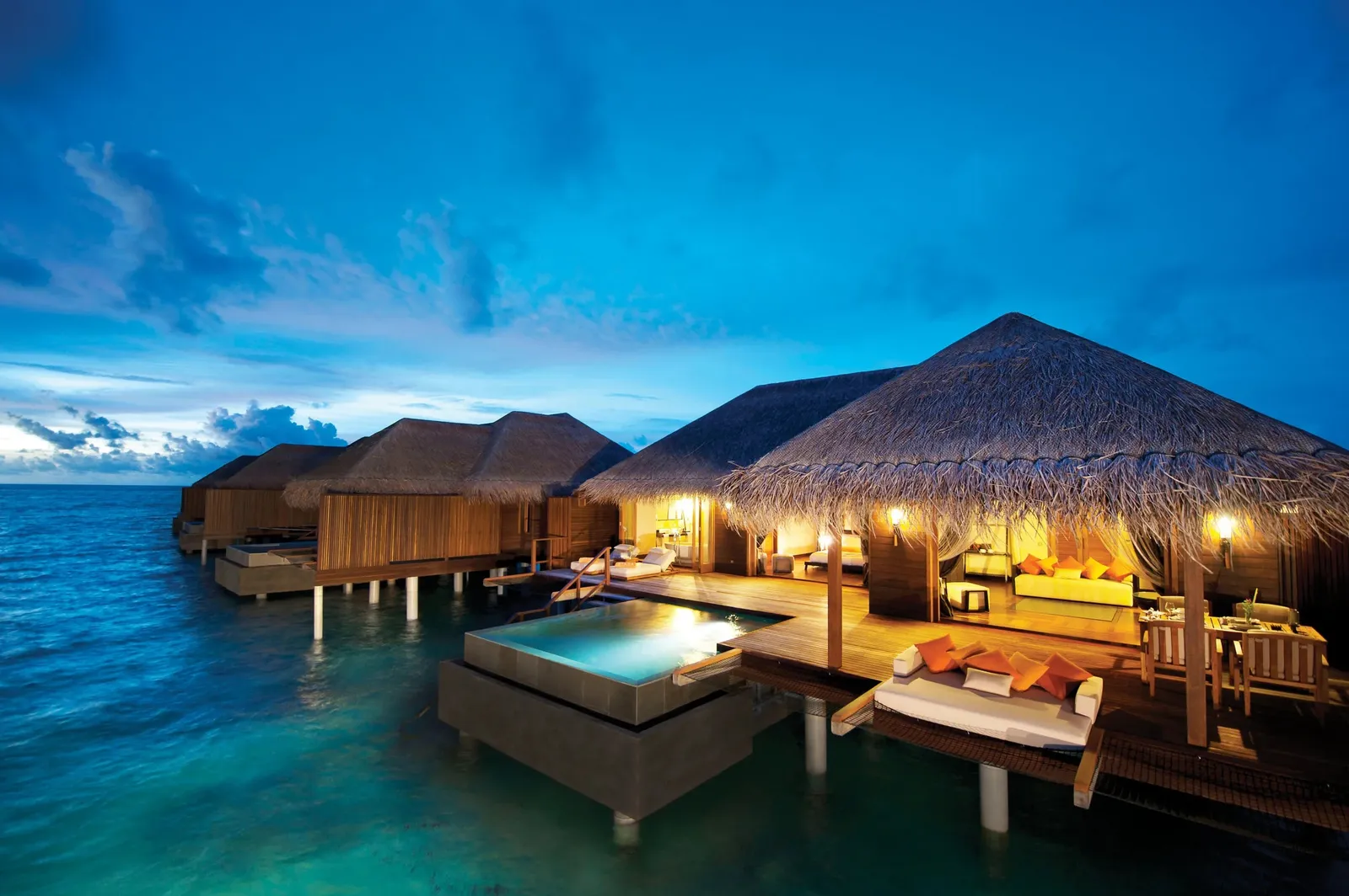 The Sunset Ocean Suites at dusk, their pools lit above the lagoon