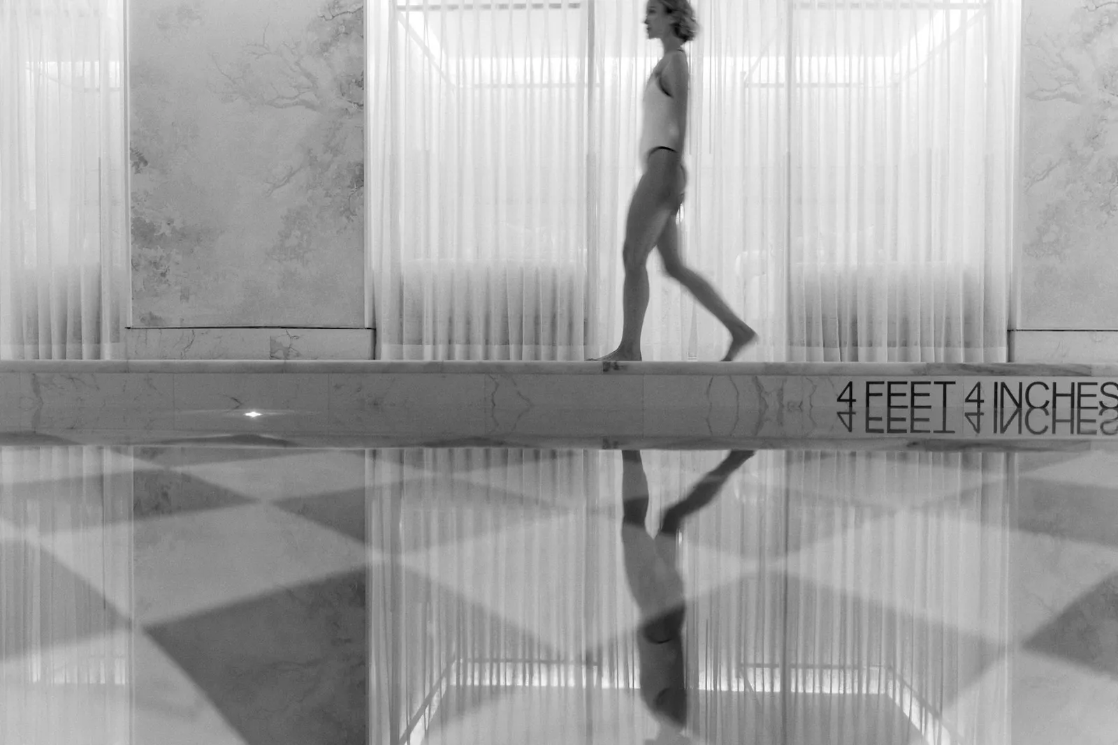 Woman walking next to the swimming pool