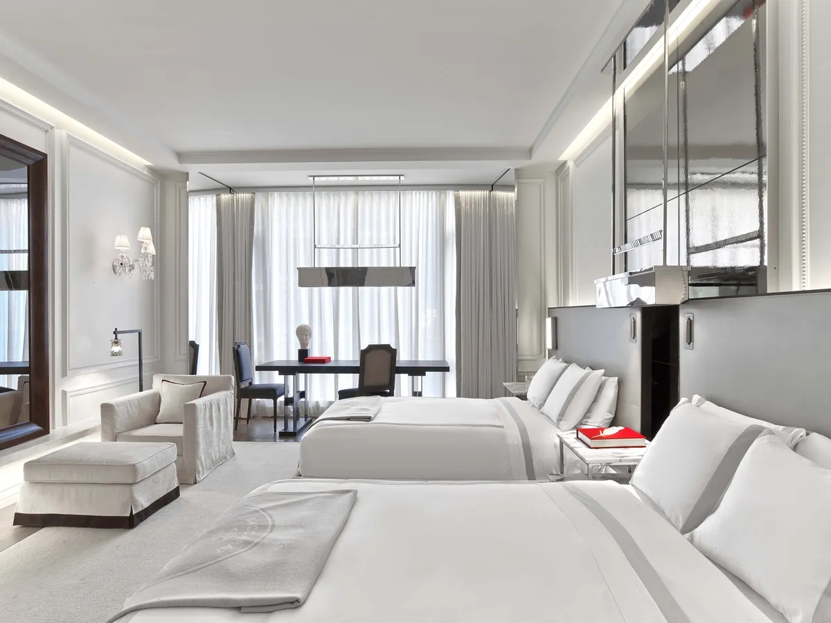 2 double beds, an armchair with footstool and a desk beside the windows